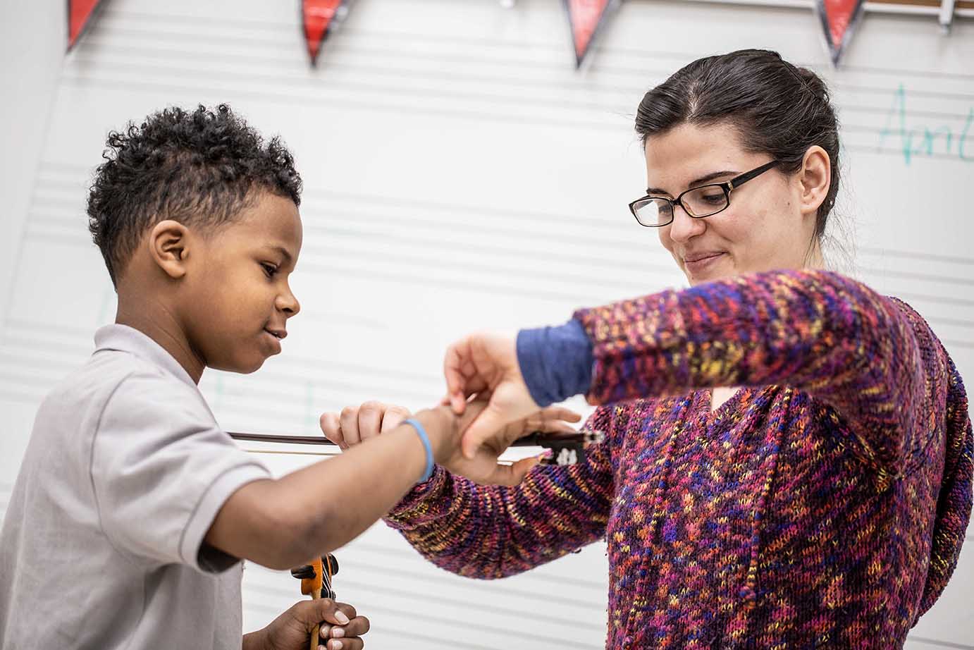 Boy being taught to play violin 